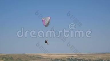 极端滑翔伞飞行在一个晴朗的蓝天，阳光照射到相机。 滑翔伞飞行体验跳伞