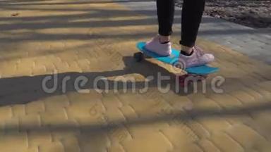 穿运动鞋的女孩在路上玩滑板