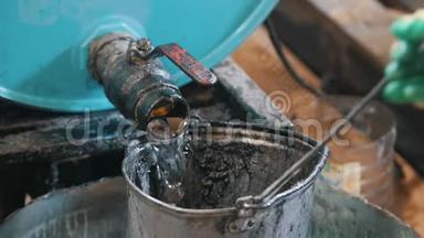 工人把<strong>发动机油</strong>或化学液体倒入旧的刮水桶中