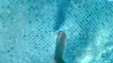 一个男孩的腿在游<strong>泳池里</strong>跳跃和<strong>玩耍</strong>，水下录像