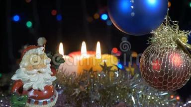 新年和圣诞装饰品。 燃烧蜡烛。 闪耀的加兰。 背景模糊。 漂亮的<strong>红球</strong>.. 圣诞老人