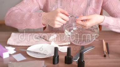 女人用尼珀切角质层。 自己修指甲。 <strong>特写双手</strong>。 手术工具放在桌子上。