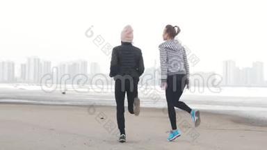 两个运动的女人站在海滩上热身跑步。 <strong>天气寒冷</strong>