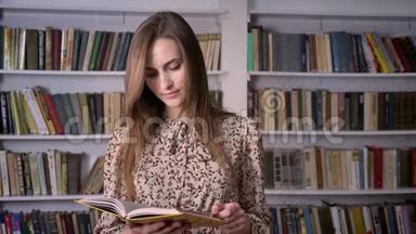 年轻漂亮的女人正在<strong>看书</strong>，在镜头前<strong>看书</strong>，在后台看<strong>图书馆</strong>
