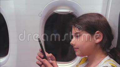 航空飞机概念。 年轻女孩正坐飞机在窗户旁边聊天，看着生活方式