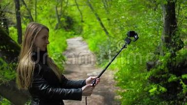 在公园里用自拍棒在动作摄像机上自拍的女人，高清视频