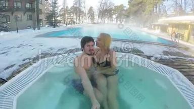 一对年轻夫妇在户外的热水浴缸里享受冬季自拍