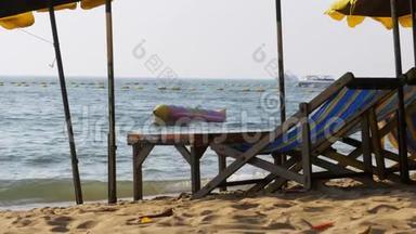 木制阳光床与伞在沙滩对海。 泰国，芭堤雅。