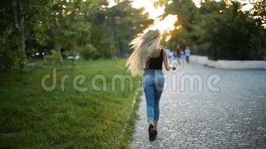 年轻的金发女郎，留着一头<strong>飘逸</strong>的长发在公园里奔跑，向夕阳西下