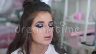 化妆师在模特眼睛下涂抹遮瑕膏