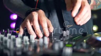 纤细的DJ手操作混音台设置。