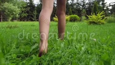 年轻女孩光着脚在绿草上走来走去