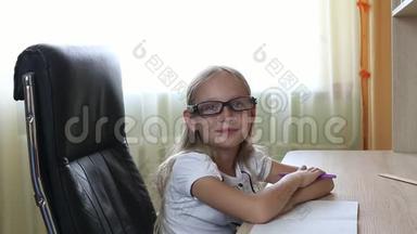 <strong>戴眼镜</strong>的年轻白种人女孩坐在桌子旁的椅子上。 印第安人在<strong>戴眼镜</strong>的<strong>漂亮</strong>女孩上近景。 白色