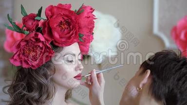 化妆师和模特一起工作。 一个年轻女孩在美容院的化妆。 化妆师用化妆