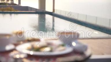 泰式菜肴.游泳池旁的桌子。 泰国传统午餐在游泳池旁，改变焦点
