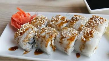 日本料理的大卷<strong>寿司</strong>放在一家时尚餐厅的桌子上，旁边是一个<strong>酱油</strong>碗