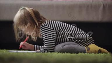 可爱的小女孩在托儿所里用铅笔画画。 小公主正在用红笔画图案。 金发美女