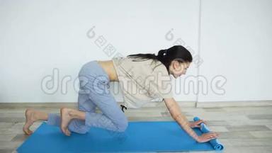 做瑜伽运动的年轻女子打开瑜伽垫