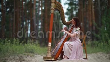 女<strong>竖</strong>琴演奏者坐在森林里，在松树的<strong>背景</strong>下演奏<strong>竖</strong>琴。