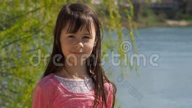 河边的女孩。 水边长着头发的小女孩。 春天阳光明媚的一天。