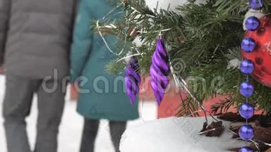 圣诞树上覆盖着雪，上面装饰着球和玩具。 在街上，有一场暴风雪。 在里面