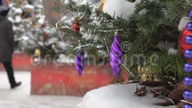 圣诞树上覆盖着雪，上面装饰着球和玩具。 在街上，有一场暴风雪。 在里面
