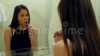 年轻漂亮的女人在浴室刷牙，因为牙齿疼痛而停止