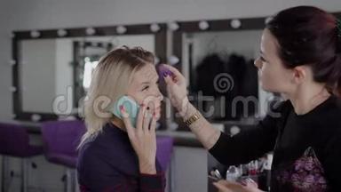 年轻的金发女商人正在豪华美容店化妆时使用她的智能手机。 个人签证申请