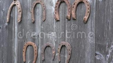 手把复古锈迹斑斑的马蹄钉放在古老的木制农村房屋墙上。 特写镜头。 4K
