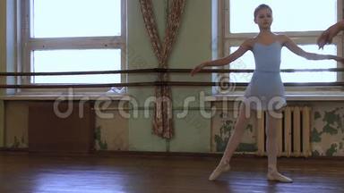 穿着蓝色紧身衣和蓝色芭蕾舞裙的女孩在破旧的教室里的<strong>舞蹈课</strong>上表演。
