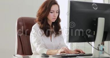 漂亮的女商人在办公室里看电脑显示器