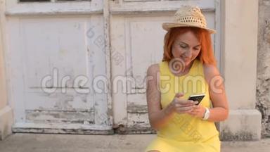 红发女游客在古城街道上使用<strong>智</strong>能手机