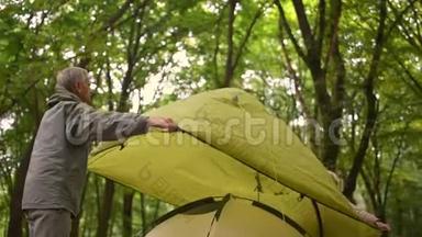 年长的活跃夫妇在树林里<strong>搭帐篷</strong>