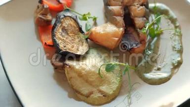 在餐馆里，厨师从一条三文鱼、烤蔬菜和排骨中准备饭菜。 概念