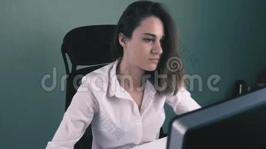 穿白衬衫的年轻女子在办公室电脑工作的肖像