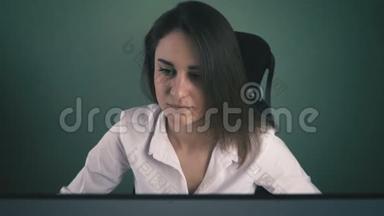 穿白衬衫<strong>的</strong>年轻女子在办公室电脑工作<strong>的</strong>肖像