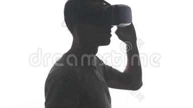 一位戴耳机的年轻人在使用VR耳机方面<strong>获得</strong>了经验，在白色背景下被隔离