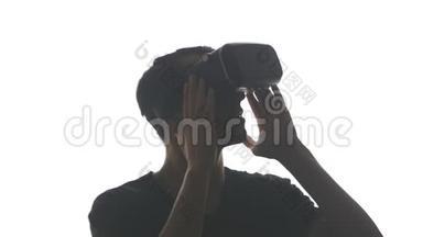 一位戴耳机的年轻人在使用VR耳机方面获得了经验，在白色背景下被隔离