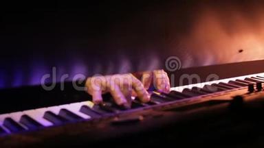 钢琴演奏者的手在夜晚的音乐会上用美妙的灯光演奏音乐
