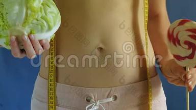 腹部平坦的女人。 蓝色背景的特写。 健康食品，健身