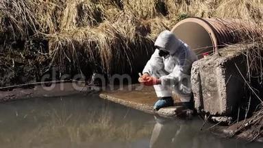 穿着生物危险服和防毒面具的人检查外面的水污染