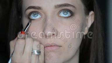 化妆师用化妆设备在模特的眼睛和眉毛上化妆。 眼部睫毛膏化妆..