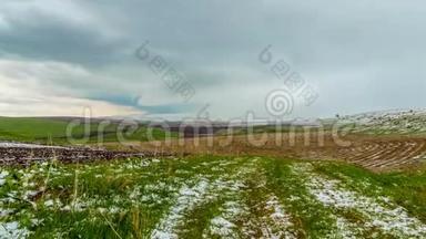4K，时间流逝。 雪落在春天的农田上，在阿克萨·德扎巴格林斯基保护区，西部田沙特。