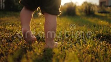 小宝宝学会走路.. 动作缓慢。 孩子们在日落时在绿草上做第一步。 快关门