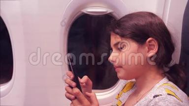 航空飞机概念。 小女孩正坐飞机在窗户旁边聊天，看着里面