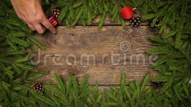 女人`手创造圣诞<strong>装饰</strong>。 圣诞<strong>树上</strong>的树枝，木纹上有圆锥和圣诞<strong>装饰</strong>
