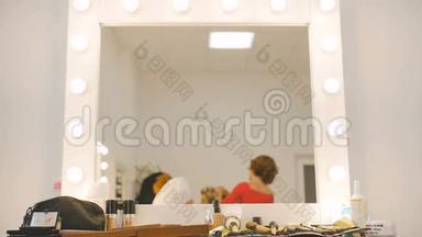 化妆师和理发师在慢动作工作室沙龙为金发模特<strong>做准备</strong>的镜像