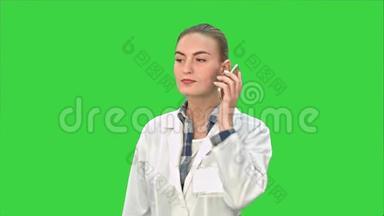 年轻的女医生打电话给病人，<strong>告诉</strong>她绿色屏幕上的好结果，Chroma键。