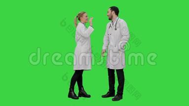 有趣的男医生在女护士上开<strong>玩</strong>笑，在绿色屏幕上给一个假的<strong>嗨</strong>五，Chroma键。