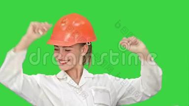 非常高兴的女人在橙色头盔<strong>赢</strong>得和庆祝她成功的胜<strong>利</strong>在绿色屏幕，Chroma键。
